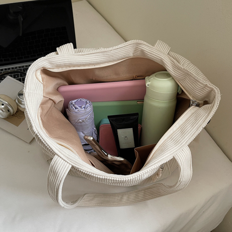 Open beige corduroy tote bag showing roomy interior and zipper pocket