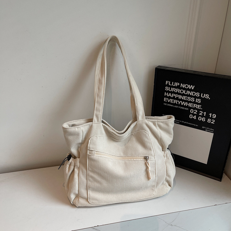 Women's beige corduroy tote bag with zipper and slouchy pockets